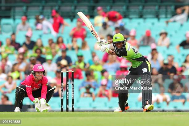 Alyssa Healy of the Sixers watches on as Harmanpreet Kaur of the Thunder bats during the Women's Big Bash League match between the Sydney Sixers and...