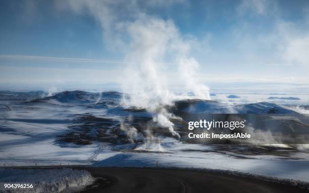 kafla thermal energy with smoke from the crater above the lava field covered by snow in winter - geothermische centrale stockfoto's en -beelden