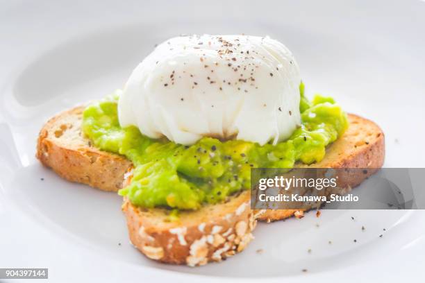 hausgemachte spiegeleiern mit zertrümmerten avocado - pochiert stock-fotos und bilder