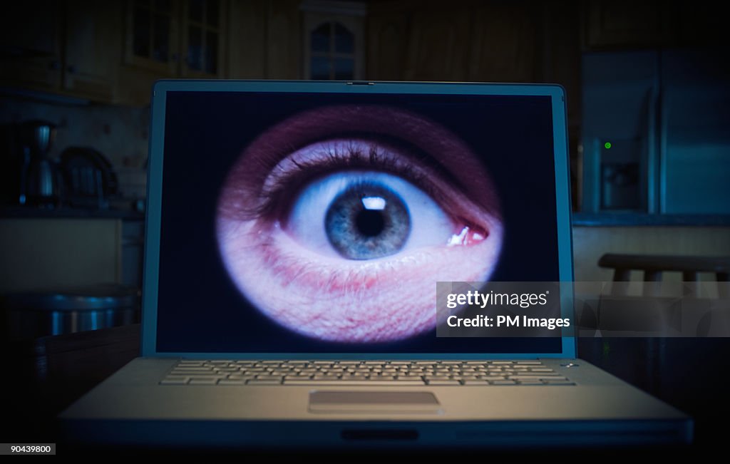 Man's eye on lap top computer