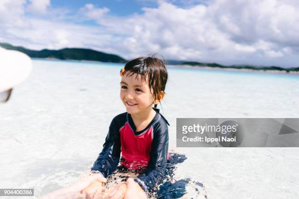 Adorable little girl playing in shallow tropical water, Zamami Island, Japan