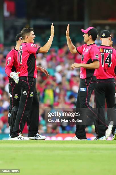 Sean Abbott of the Sixers celebrates with Moises Henriques of the Sixers after taking the wicket of Shane Watson of the Thunder during the Big Bash...