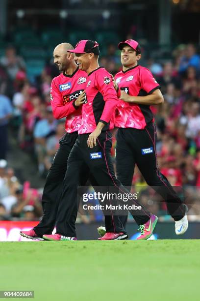 Nathan Lyon of the Sixers celebrates with his team mates Johan Botha and Moises Henriques after taking the wicket of James Vince of the Thunder...