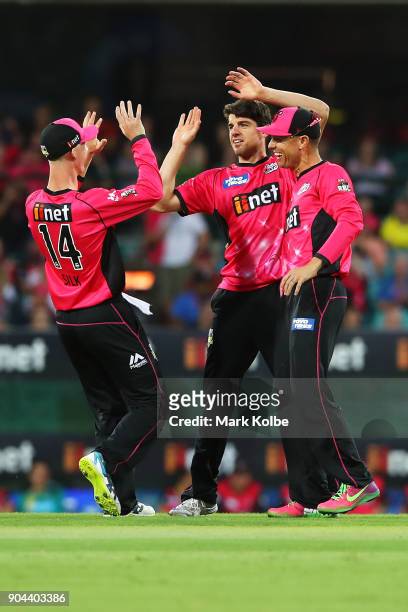 Moises Henriques of the Sixers celebrates with his team mates Jordan Silk and Johan Bothan of the Sixers after taking the wicket of Callum Ferguson...