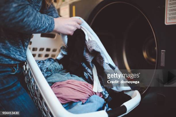 close-up of a woman with a laundry basket washing clothes - roupa imagens e fotografias de stock