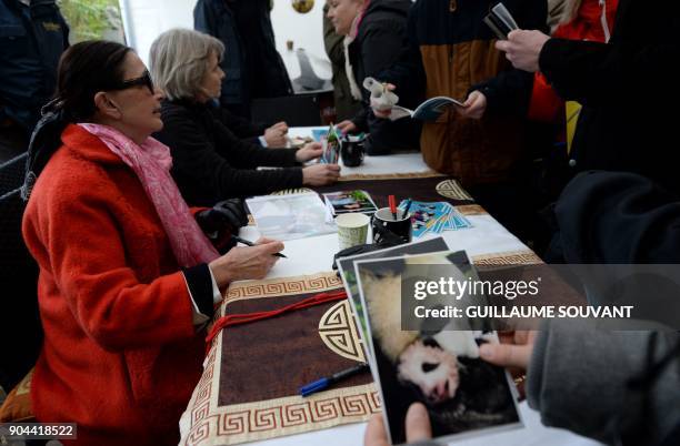 Founder of the Beauval zoo, Francoise Delord signs photos of the Panda cub Yuan Meng and its mother Huan Huan, during the cub's first public...
