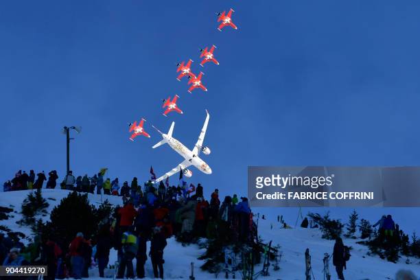 Fighter jets of the "Patrouille Suisse" and an commercial plane fly over the slopes ahead of the Downhill race at the FIS Alpine Skiing World Cup in...