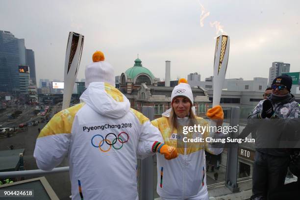 Torch bearers hold the PyeongChang 2018 Winter Olympics torch during the PyeongChang 2018 Winter Olympic Games torch relay on January 13, 2018 in...