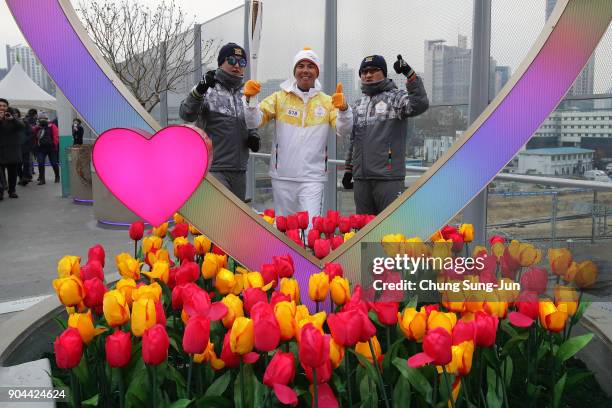 Torch bearer holds the PyeongChang 2018 Winter Olympics torch during the PyeongChang 2018 Winter Olympic Games torch relay on January 13, 2018 in...