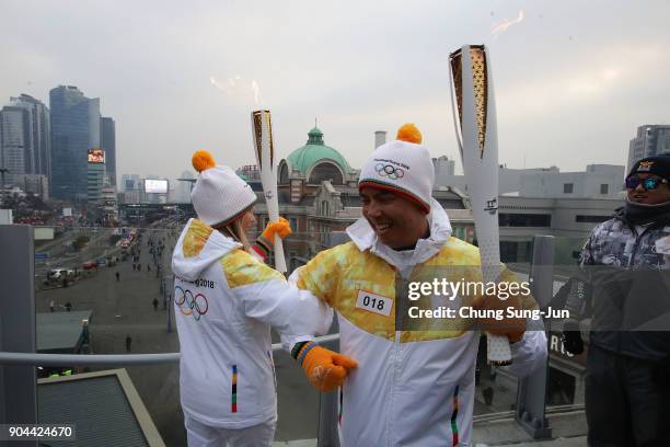 Torch bearers hold the PyeongChang 2018 Winter Olympics torch during the PyeongChang 2018 Winter Olympic Games torch relay on January 13, 2018 in...