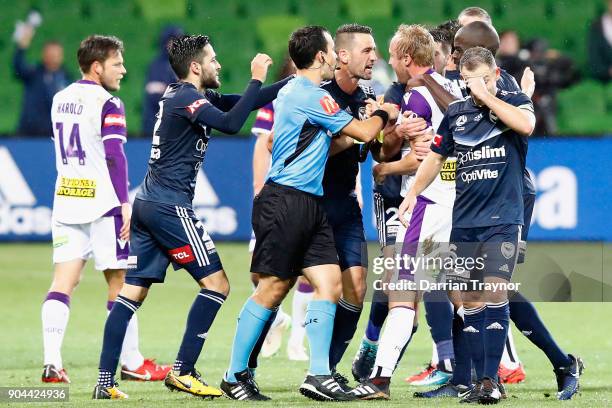 Carl Valeri of Melbourne Victory argues with Mitchell Nichols and Alex Grant of Perth Glory after Grant put a crud tacle on Leroy George of the...