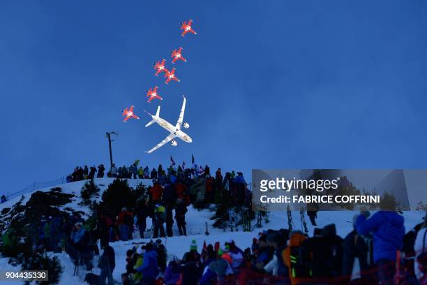 Fighter jets of the "Patrouille Suisse" and an commercial plane fly over the slopes ahead of the Downhill race at the FIS Alpine Skiing World Cup in...