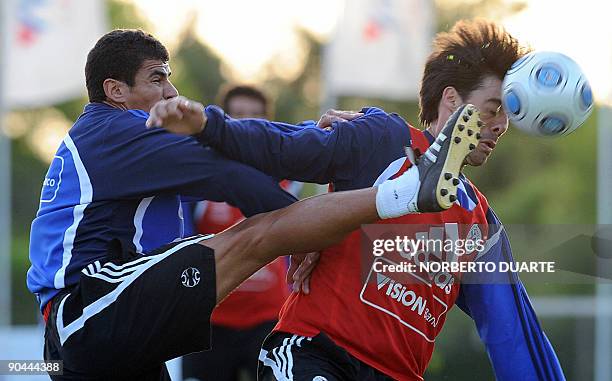 Paraguay's defenders Carlos Bonet and Julio Caceres fight for the ball during a training session in Ypane, Paraguay, on September 8, 2009. Paraguay...
