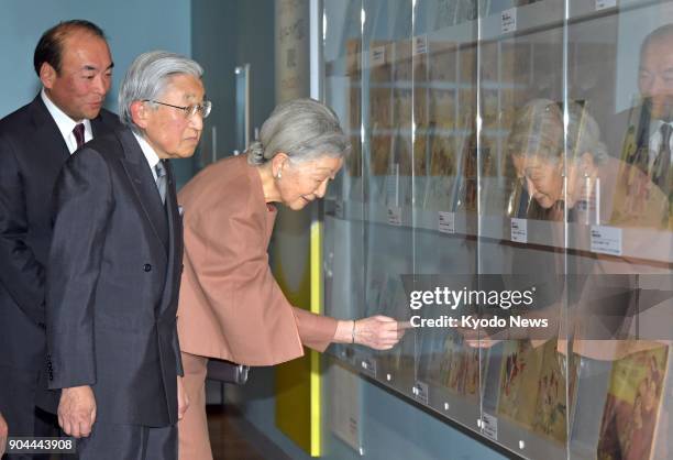 Japanese Emperor Akihito and Empress Michiko look at displays of children's books at the "90 Years of Kinderbook" exhibition held at Tokyo's Printing...