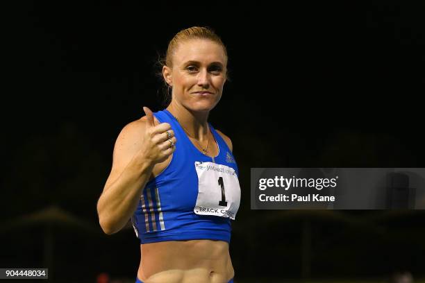 Sally Pearson acknowledges the spectators after competing in and winning the women's 100 metre hurdles during the Jandakot Airport Perth Track...