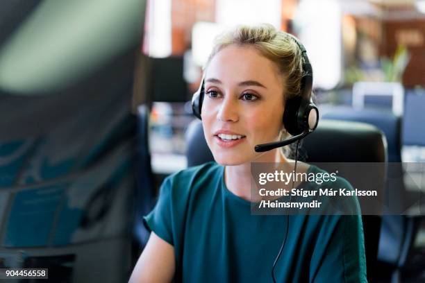 smiling businesswoman wearing headset at office - headset imagens e fotografias de stock