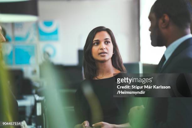 smiling businesswoman discussing with coworkers - serious stock pictures, royalty-free photos & images