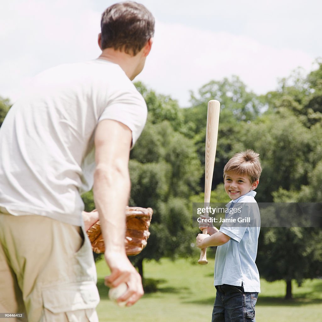 Father pitching baseball to son