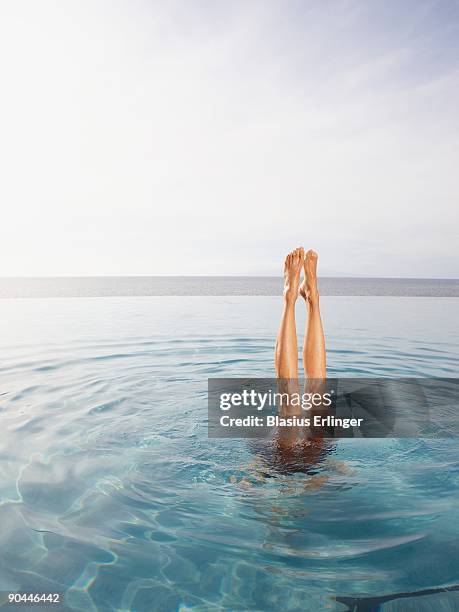 womans legs sticking out of pool - synchronized swimming stock pictures, royalty-free photos & images