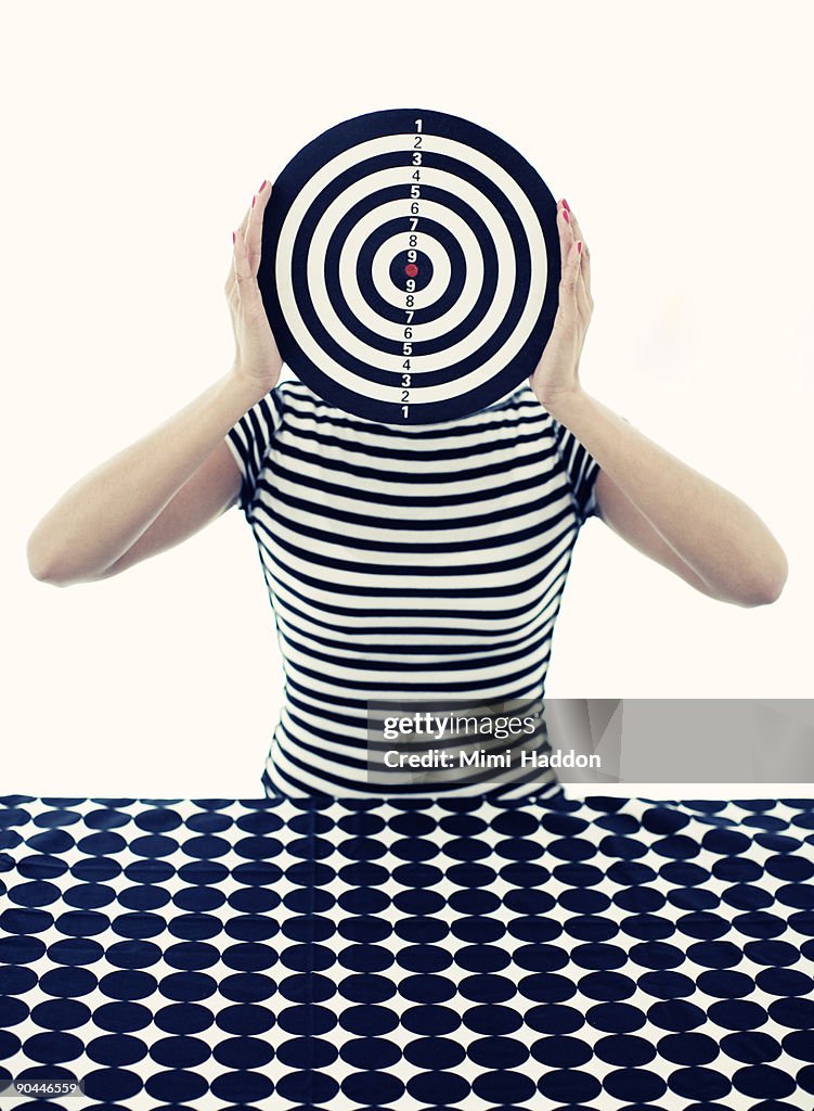 Woman Holding Bullseye in Front of Face