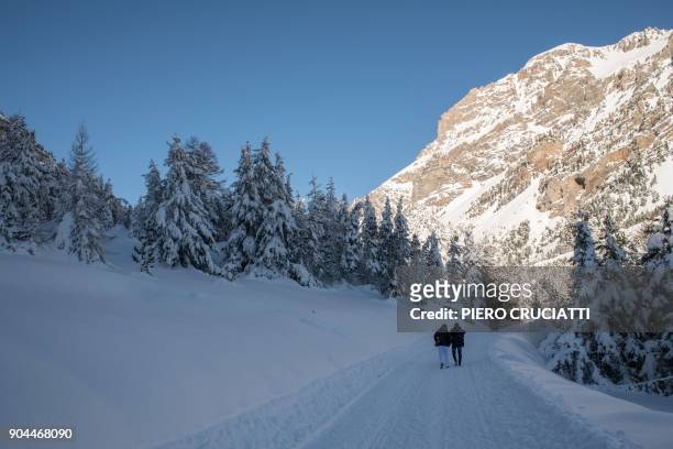 Migrants from Ivory Coast walk in the snow on their way to the Colle della scala a snow-covered pass to cross the border between Italy and France, on...