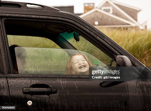 girl (2-3) pressing face against car window - outdoor entertaining stock-fotos und bilder