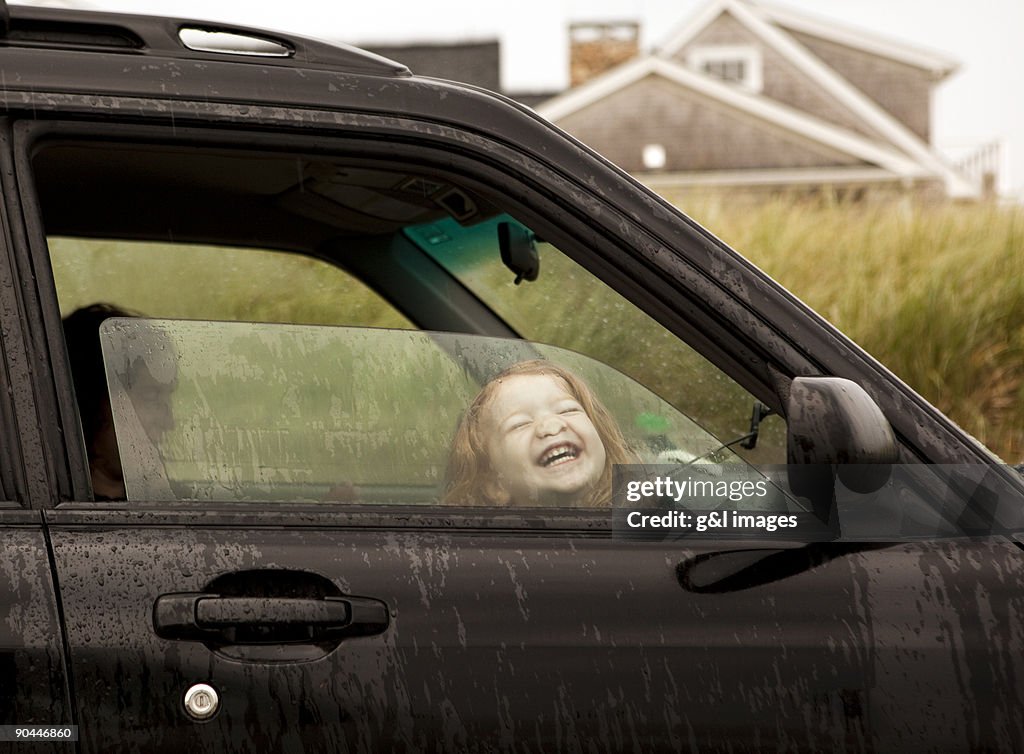 Girl (2-3) pressing face against car window