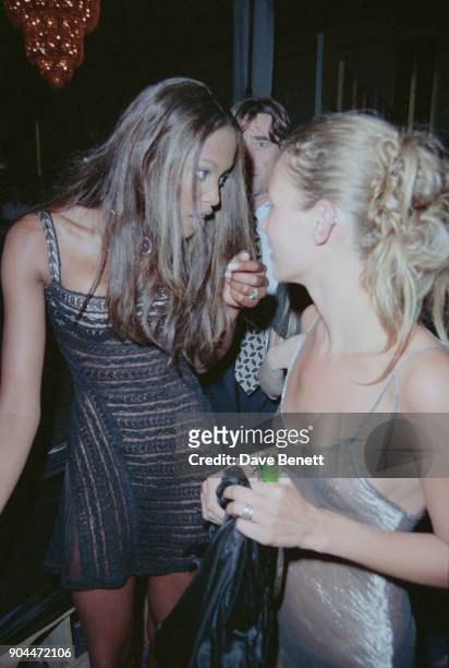 British supermodels Naomi Campbell, wearing a short semi-transparent black dress, and Kate Moss, wearing a transparent sheer slip dress, at the Elite...