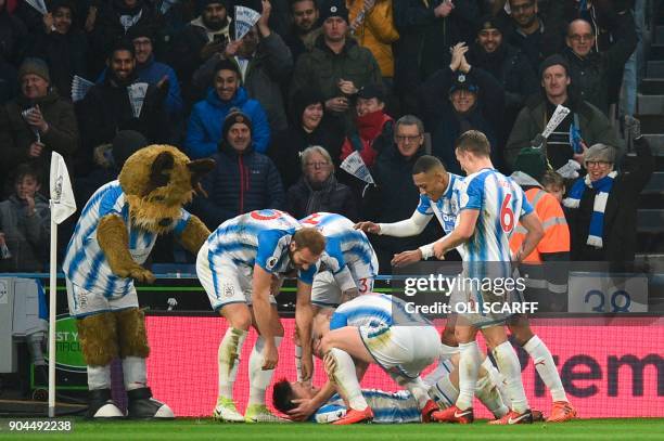 Huddersfield Town's English midfielder Joe Lolley celebrates with team-mates after scoring their first goal to equalise 1-1 during the English...