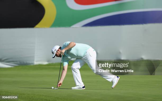 Branden Grace of South Africa lines up a putt on the 18th green during the third round of the BMW South African Open Championship at Glendower Golf...