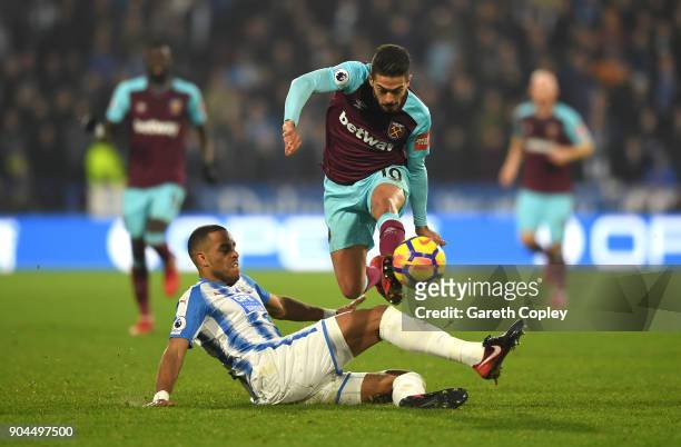 Manuel Lanzini of West Ham United is tackled by Mathias Jorgensen of Huddersfield Town during the Premier League match between Huddersfield Town and...