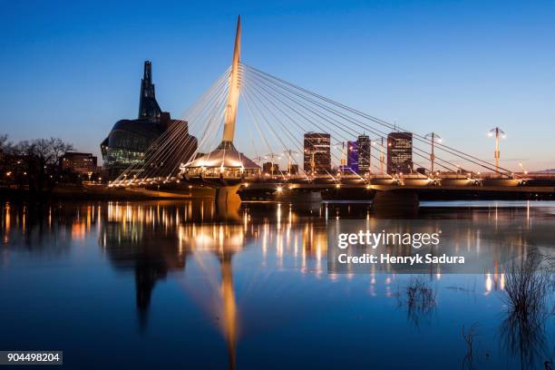 canada, manitoba, winnipeg, red river reflecting esplanade riel bridge - winnipeg stock pictures, royalty-free photos & images