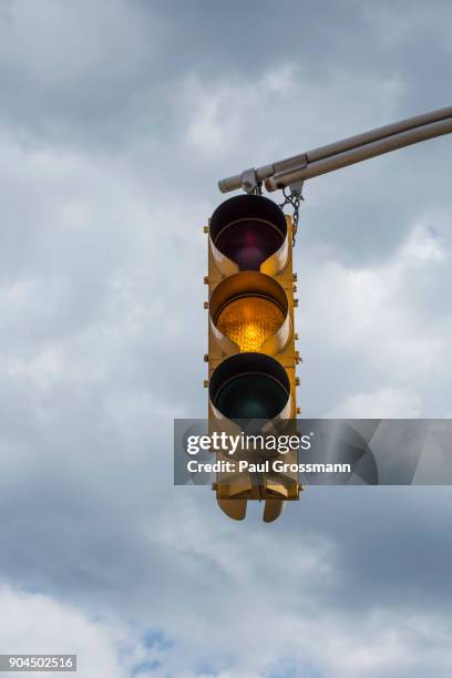 traffic light against storm clouds - yellow light stock pictures, royalty-free photos & images