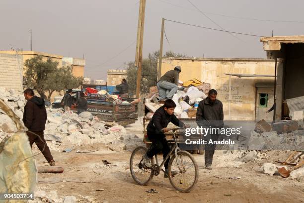 People move away to safe areas after collecting their belongings following an airstrike at Khan al-Sabil village in Idlib, Syria on January 13, 2018....