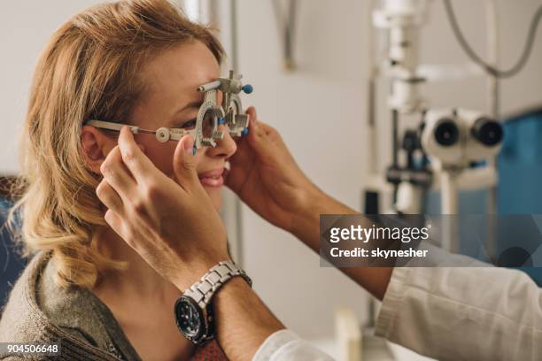 donna sorridente che fa controllare la vista con l'attrezzatura per il test oculare. - measure foto e immagini stock