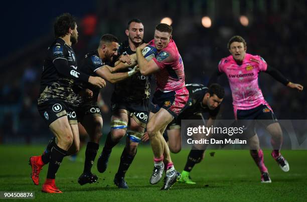 Sam Simmonds of Exeter Chiefs is tackled by Aaron Cruden and Louis Picamoles of Montpellier during the European Rugby Champions Cup match between...