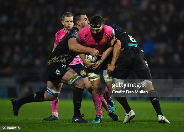 Don Armand of Exeter Chiefs is tackled by Louis Picamoles and Julien Bardy of Montpellier during the European Rugby Champions Cup match between...