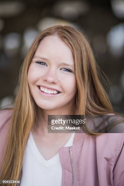portrait of smiling blond girl standing at parking garage - 12 year old blonde girl stock pictures, royalty-free photos & images