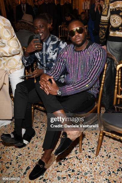 Maître Gims and a guest attend the Versace show during Milan Men's Fashion Week Fall/Winter 2018/19 on January 13, 2018 in Milan, Italy.