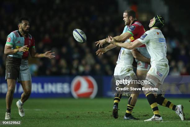 Jamie Roberts passes the ball to Alofa Alofa of Harlequins as he is tackled by Kyle Eastmond and James Gaskell of Wasps during the European Rugby...