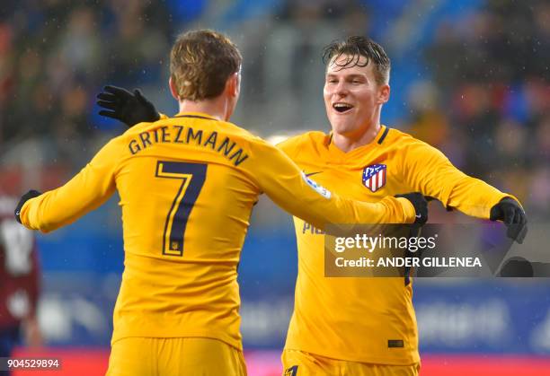 Atletico Madrid's French forward Kevin Gameiro is congtratulated by teammate French forward Antoine Griezmann after scoring his team's first goal...