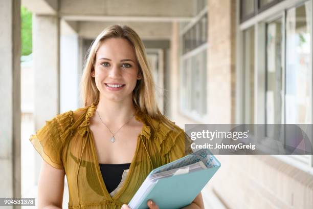 school teacher smiling towards camera with file - teacher with folder stock pictures, royalty-free photos & images