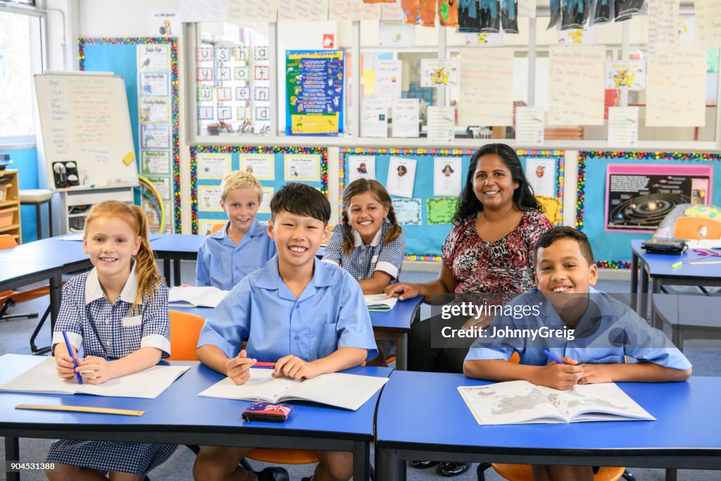 Portrait of five primary school children in classroom with their teacher