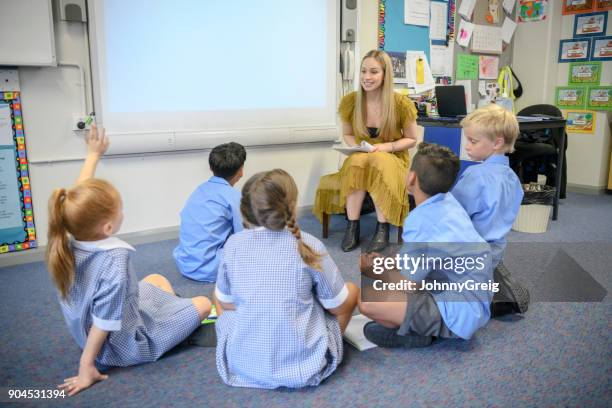 group of school children sitting on the floor listening to their teacher - child on carpet stock pictures, royalty-free photos & images