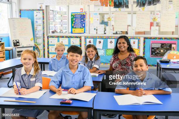 well behaved school children sitting at their desks with their teacher - native korean stock pictures, royalty-free photos & images