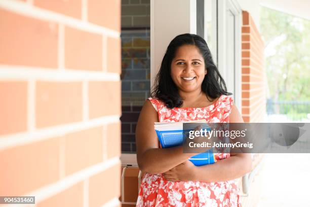 portret van aboriginal onderwijzer houden van studieboeken - australian culture stockfoto's en -beelden