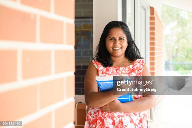 porträtt av aboriginska skolläraren holding läroböcker - australian culture bildbanksfoton och bilder