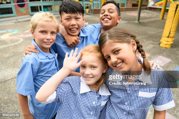 five school friends posing for candid photo in playground - school uniform stock pictures, royalty-free photos & images