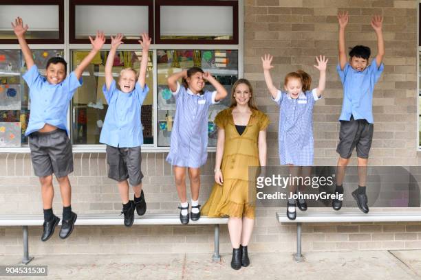 young female teacher in front of five children jumping and shouting - native korean stock pictures, royalty-free photos & images
