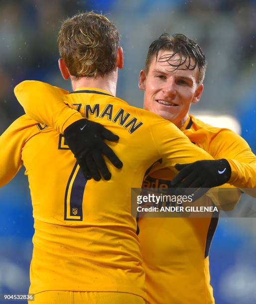 Atletico Madrid's French forward Kevin Gameiro is congtratulated by teammate French forward Antoine Griezmann after scoring his team's first goal...